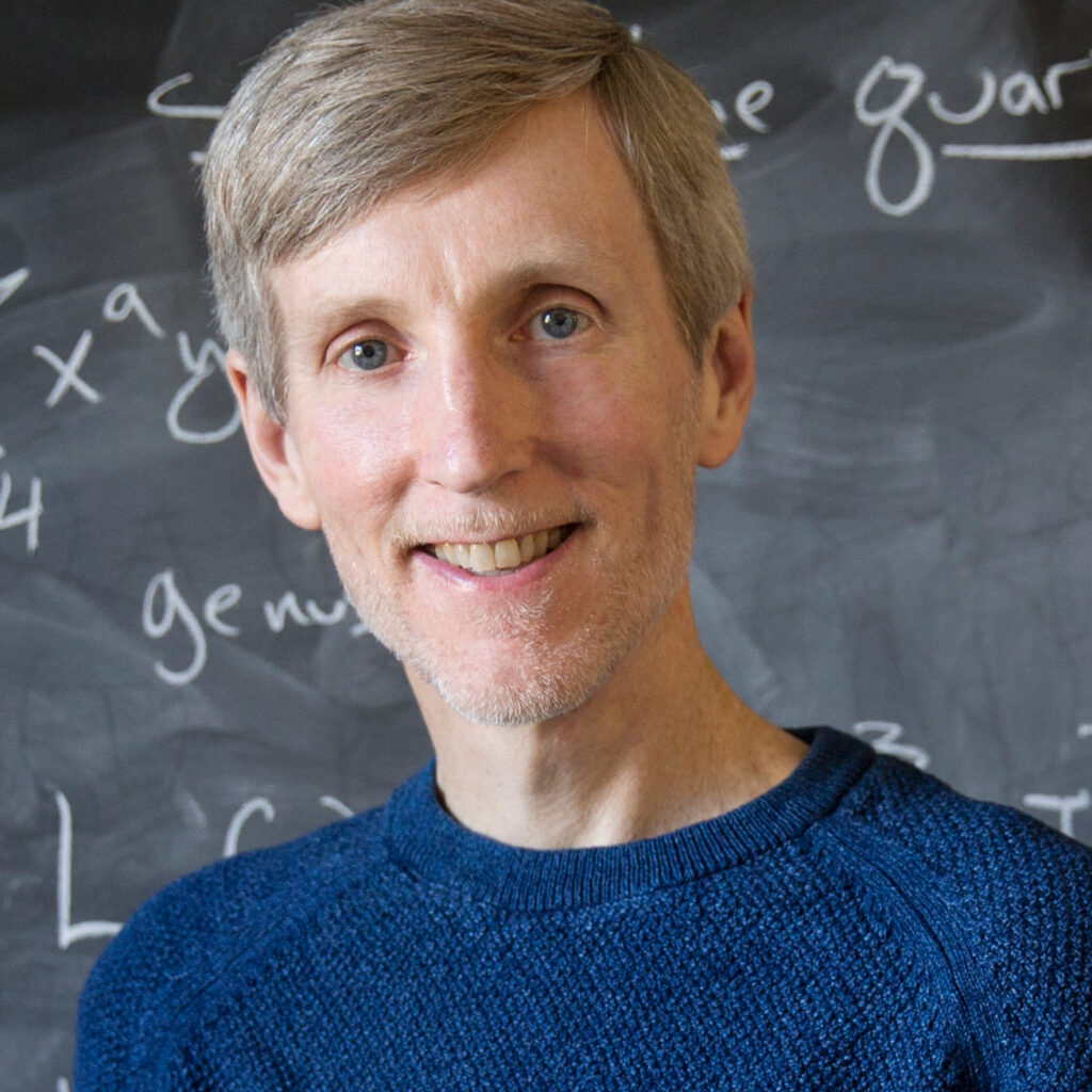 Andrew Sutherland in front of a chalkboard