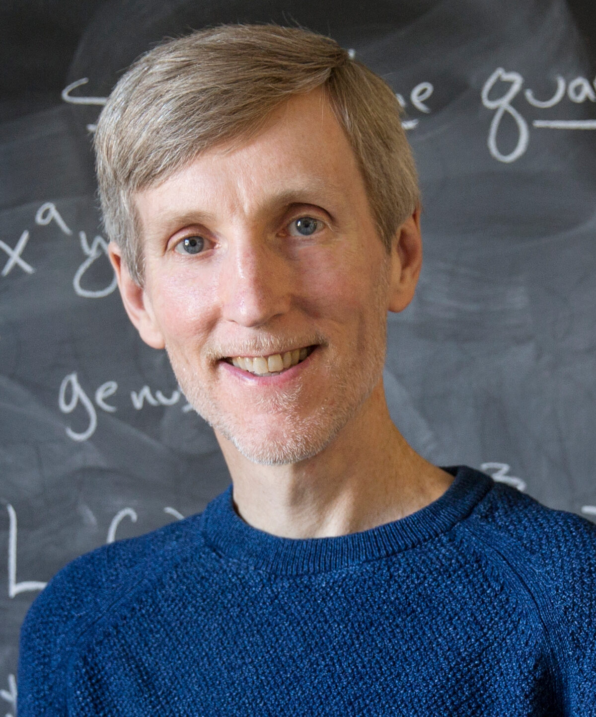 Andrew Sutherland in front of a chalkboard