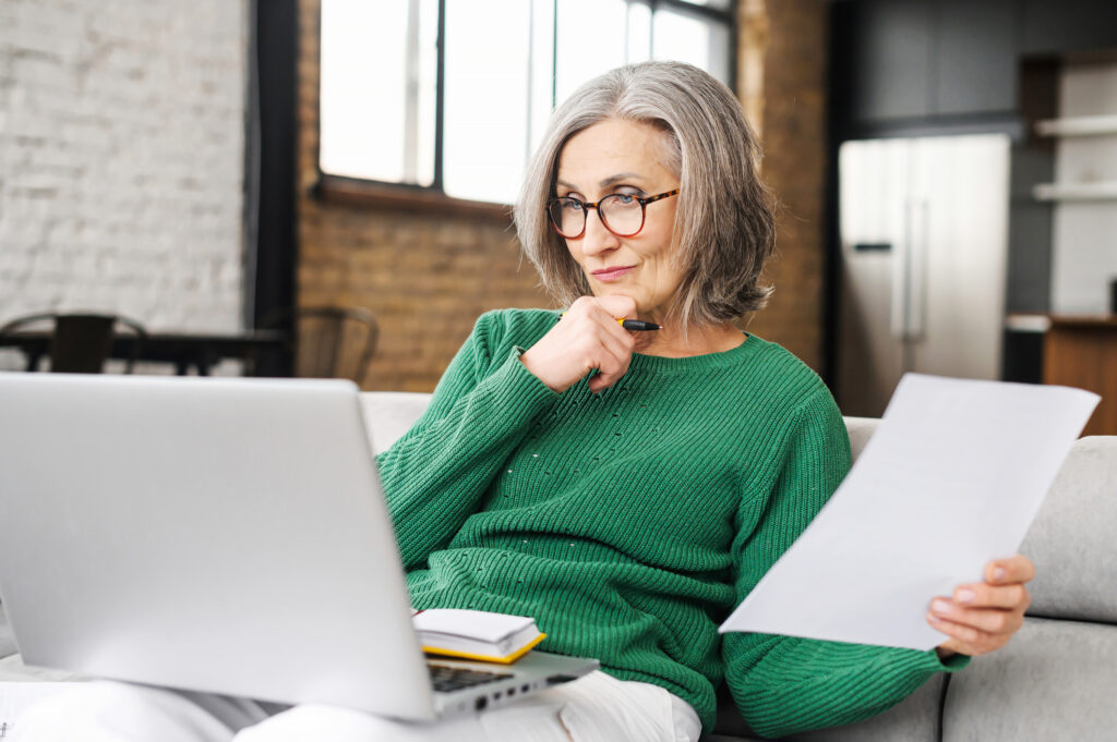 Woman with grey hair looking at laptop