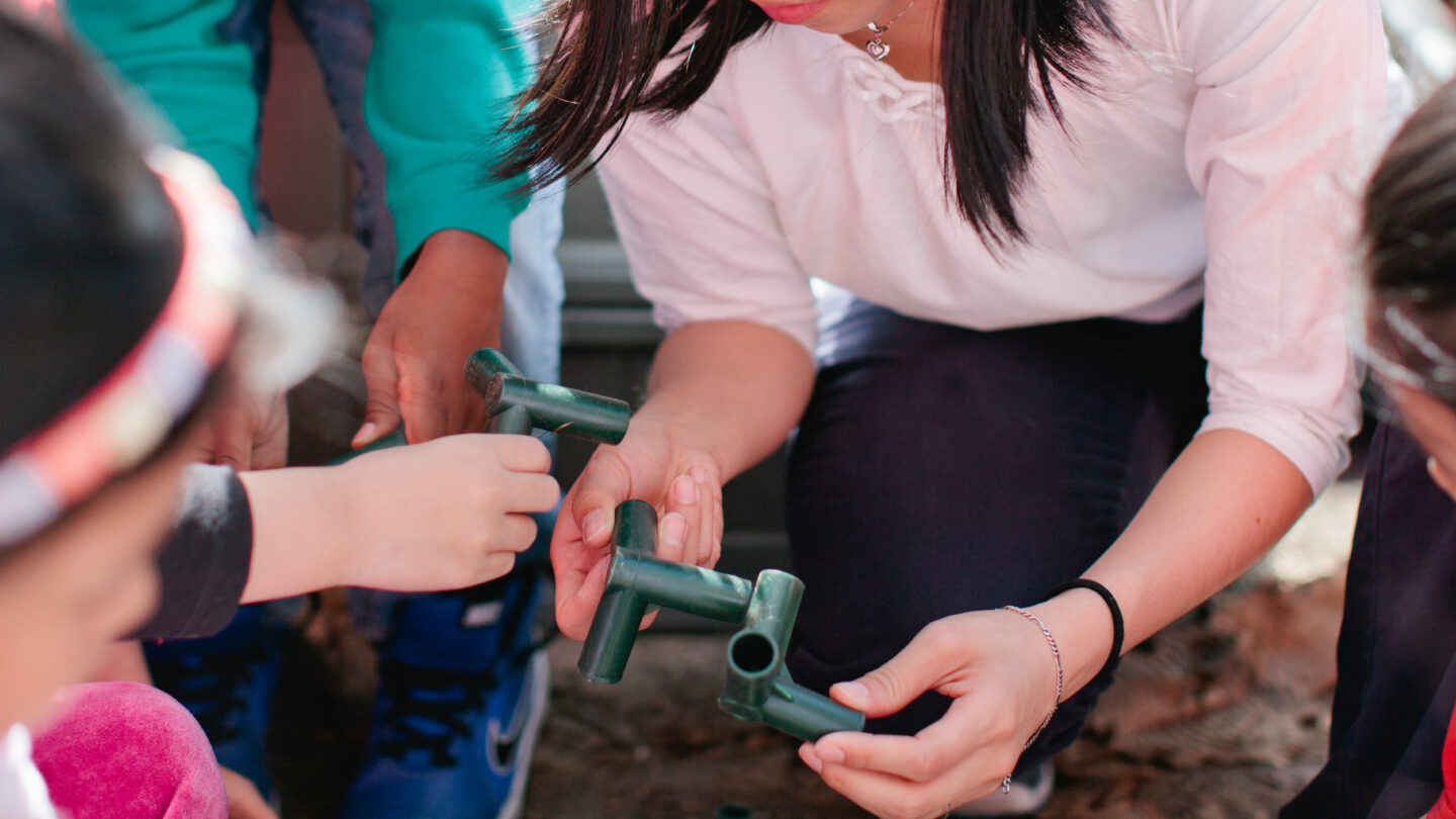 Hands of children connecting pipes together
