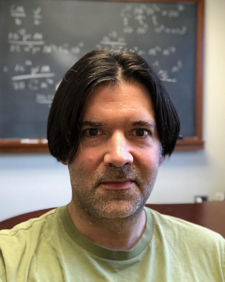 Neal Weiner in front of a chalkboard