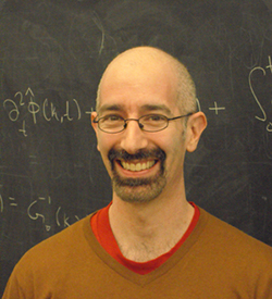 David R Reichman in front of a chalkboard