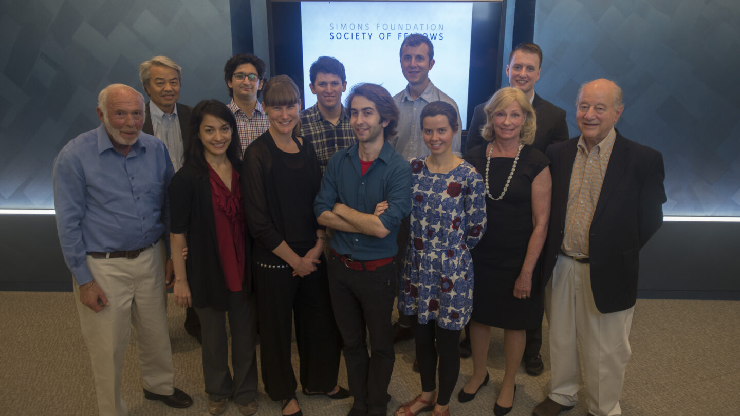 12 people standing in front of a glowing sign that says 