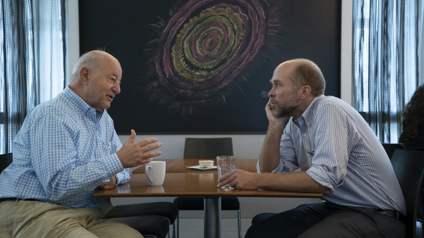 Image of SFARI science meeting attendees talking together.