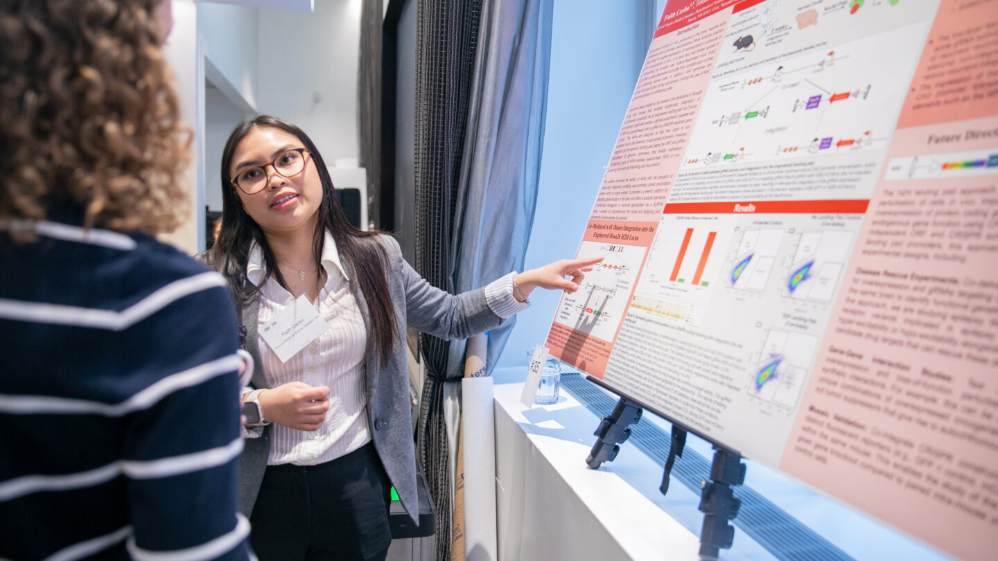 A photo of Faith Cerbo presenting her poster at the SURFiN Symposium.