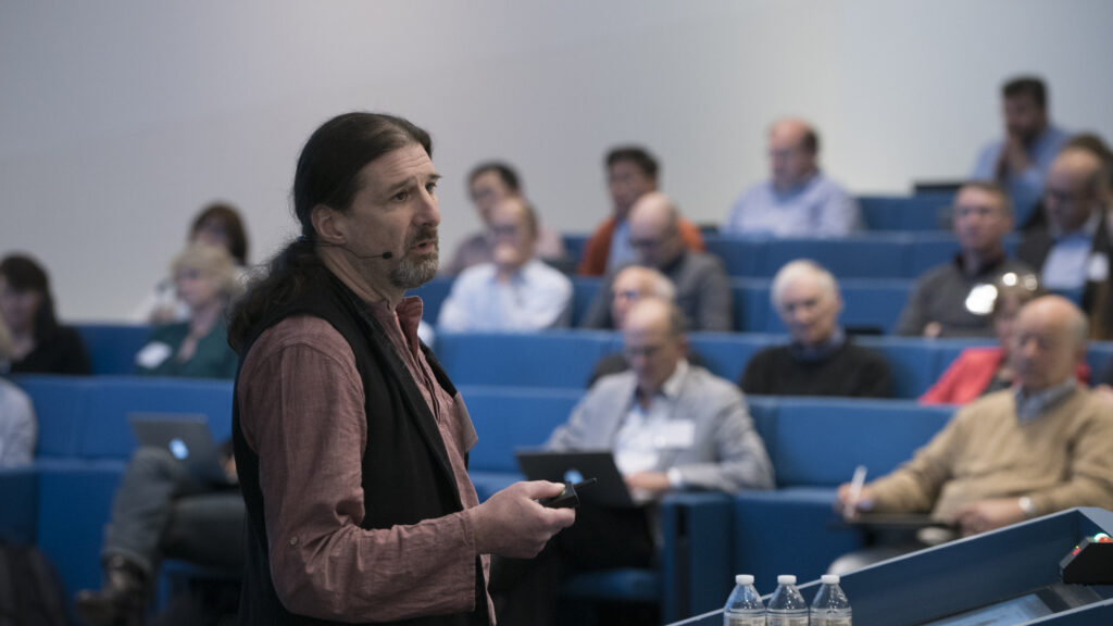 Side view of Peter Kind discussing findings from his research at a conference