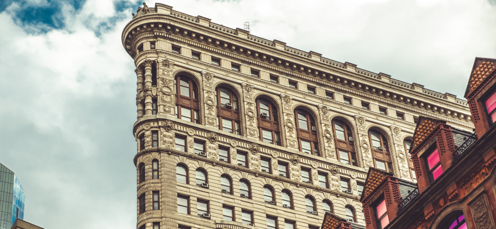 The Flatiron Building in New York City viewed from the street level.