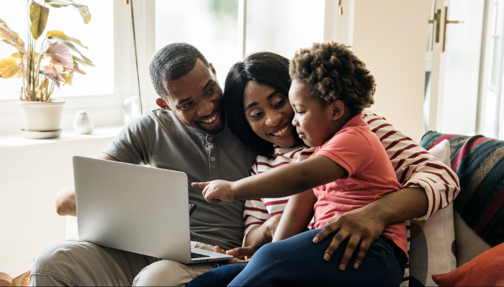 Image of family in living room looking at laptop together