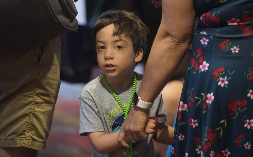 Image of boy holding hands with an adult