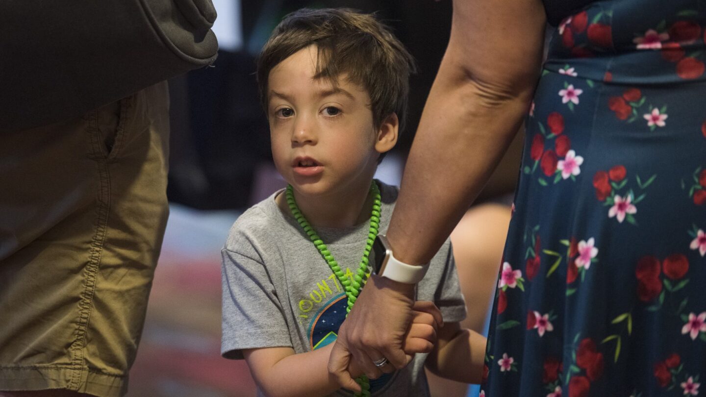 Image of boy holding hands with an adult