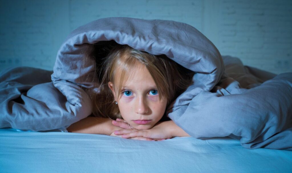 Image of girl under blanket