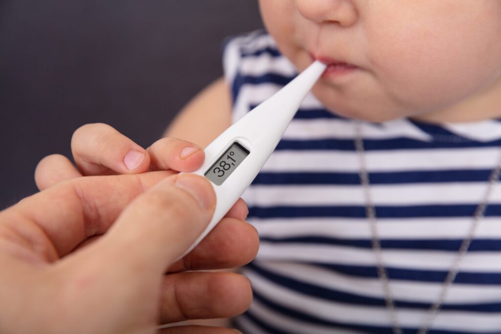 Person's Hand Checking Fever Of Sick Girl