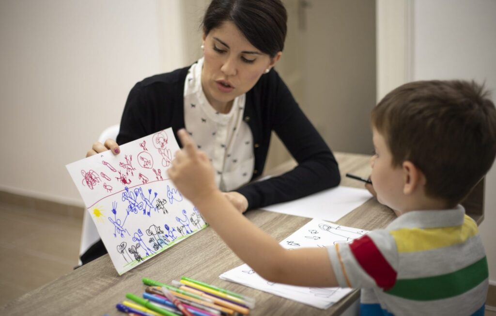 Image of boy showing drawing to woman
