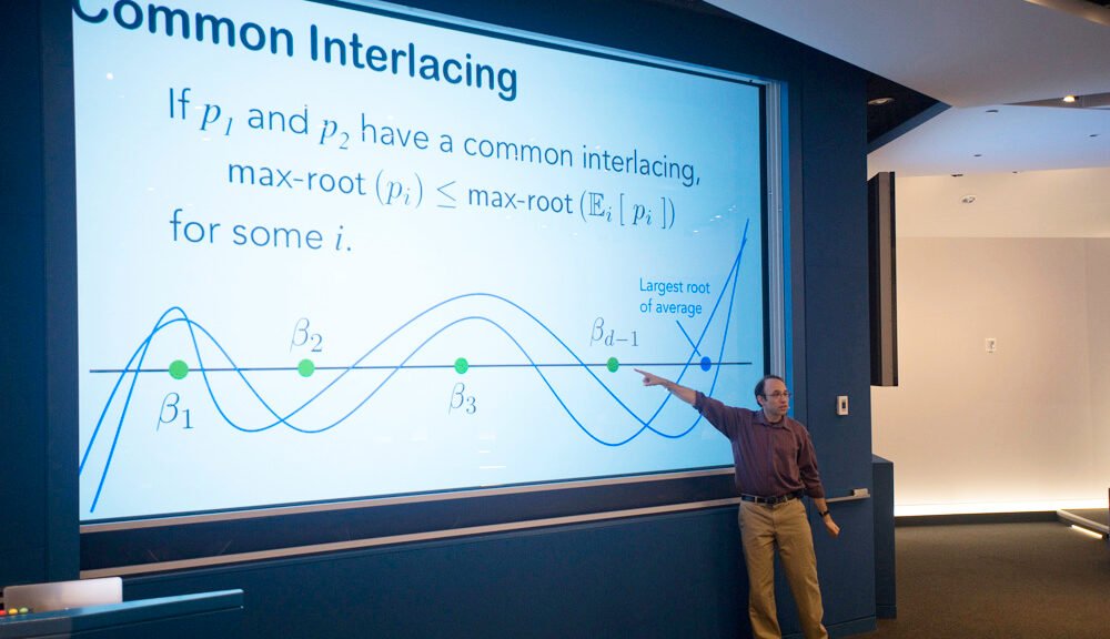 Man presenting a slideshow titled Common Interlacing