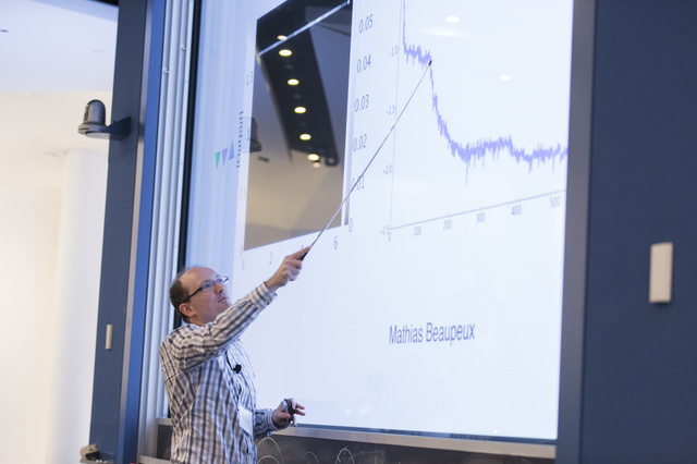 Paul François using a metal stick to point to a graph on a slideshow