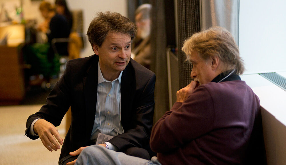 Two people sitting by a window and talking