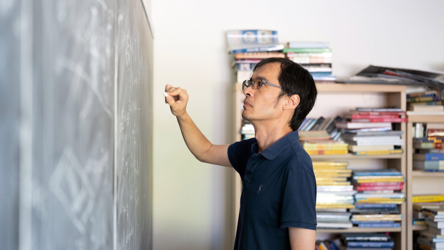 A portrait of Terry Tao near a chalkboard, taken at UCLA.