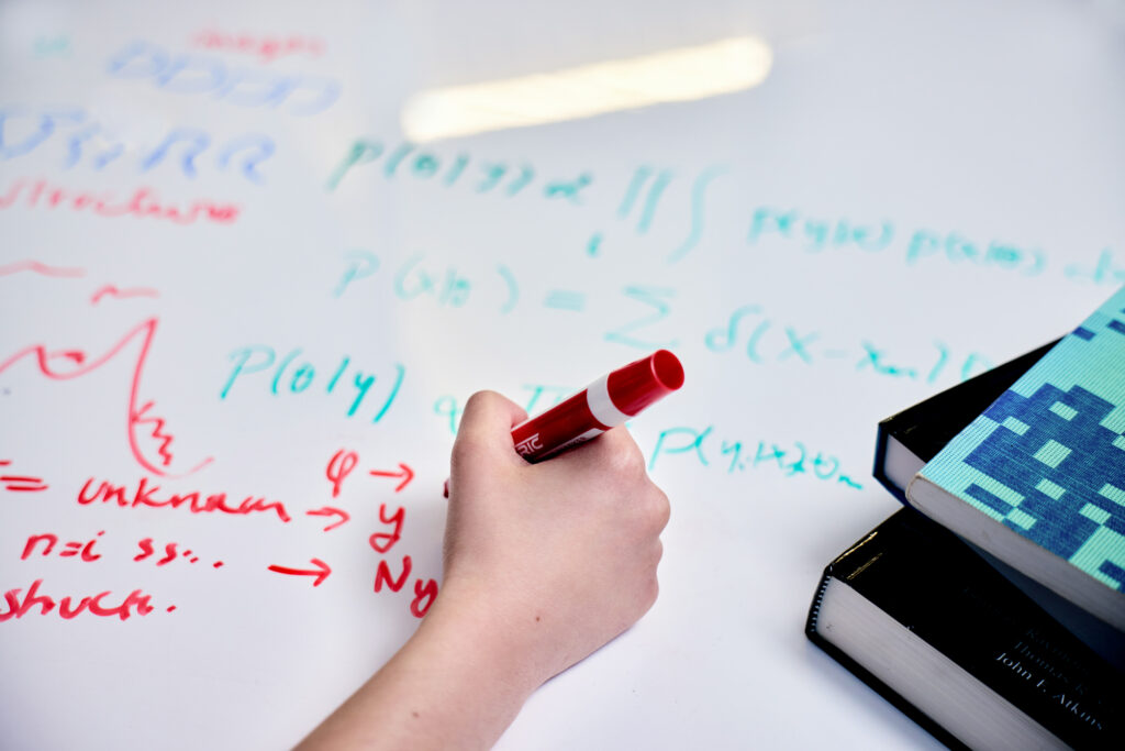 A photo of a close-up of Pilar Cossio’s handwriting on her whiteboard table with a dry-erase marker.