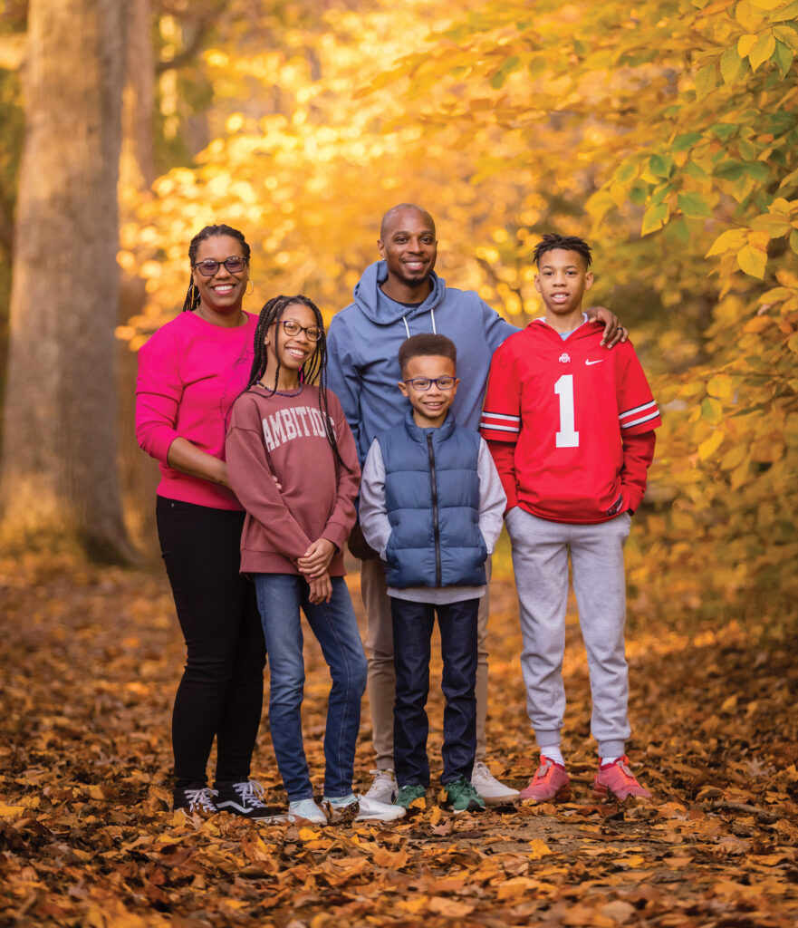 Photo of five people with trees behind them.