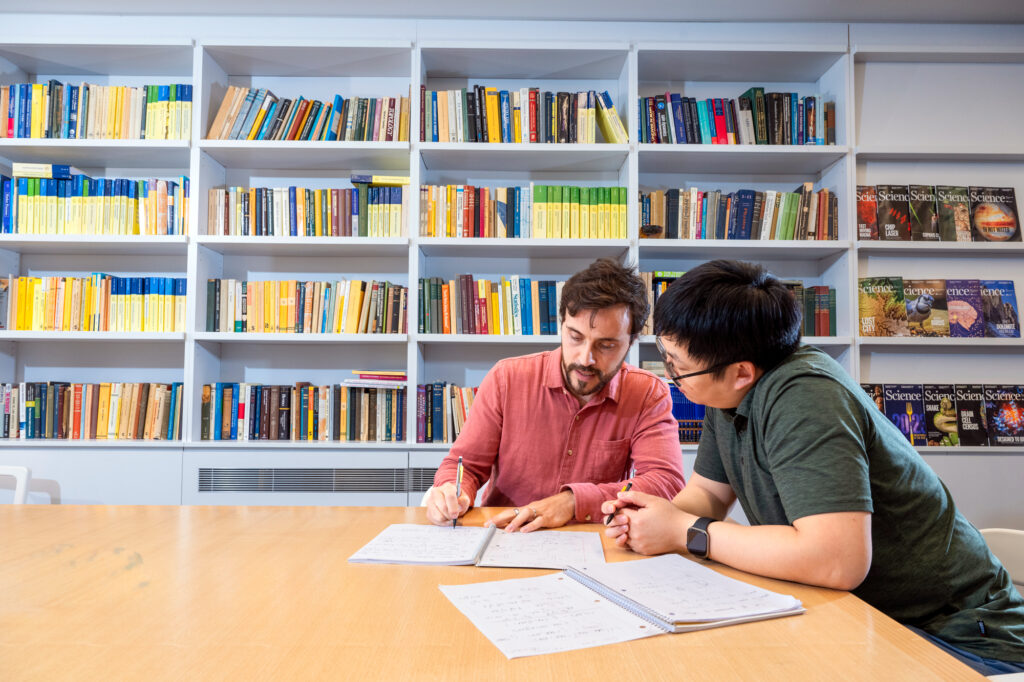 A photo of two mathematicians sitting in a library.
