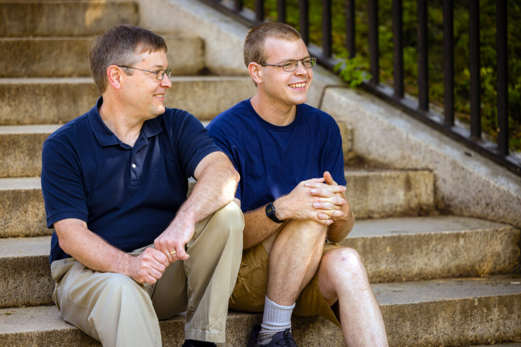A photo of a father and son sitting on steps.