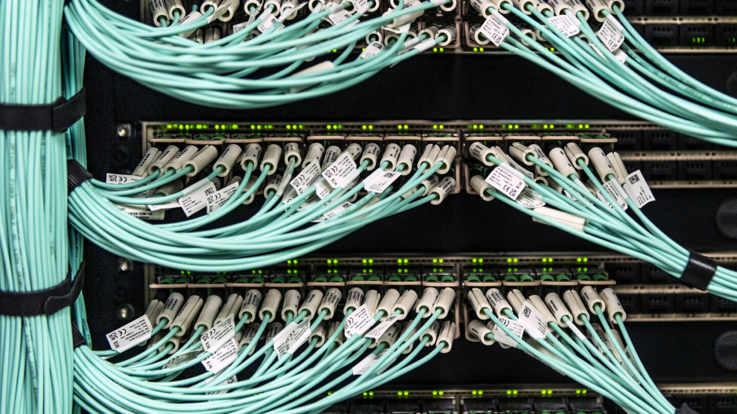 Photo of Empire AI servers with numerous cables and wires visible.