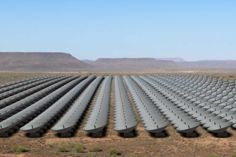 A vast array of satellite dishes arranged in rows across a desert landscape.