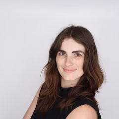 A young woman with brown hair smiling at the camera.